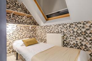 Un dormitorio con una cama en una habitación con azulejos. en Gites Spa Strasbourg - Villa Cerf - SPA Privé, Sauna, Borne d'arcade, Babyfoot, en Ittenheim 51 fotos más