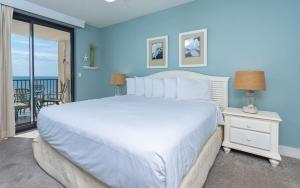 une chambre avec un grand lit blanc et un balcon dans l'établissement Phoenix X 711 condo, à Orange Beach 39 autres photos