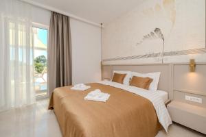 a bedroom with a large bed with two towels on it at Villa Nexia Šibenik in Šibenik +40 photos