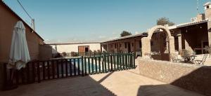 una recinzione accanto a un edificio con piscina di Apartamentos El Paso a Pedrera