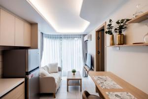 eine Küche und ein Wohnzimmer mit Kühlschrank und Tisch in der Unterkunft Fantasea Kamala 1 BR Apartments Near Beach 212 in Kamala Beach