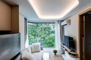 ein Wohnzimmer mit großem Fenster und einer Couch in der Unterkunft Fantasea Kamala 1 BR Apartments Near Beach 212 in Kamala Beach