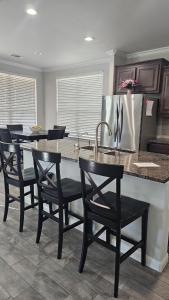 una cucina con un bancone con sedie e un frigorifero di Prime Location Home Family & Business Ready a Midland