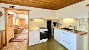 une cuisine avec un évier et une cuisinière dans l'établissement Ferienhaus Faulensee, à Rieden 6 autres photos