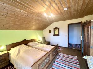a bedroom with a bed with a wooden ceiling at Ferienhaus Faulensee in Rieden +5 photos