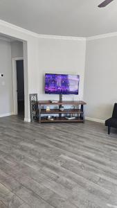 un soggiorno con TV a schermo piatto su una parete bianca di Prime Location Home Family & Business Ready a Midland
