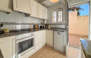 eine Küche mit weißen Schränken, einer Spüle und einem Geschirrspüler in der Unterkunft Lovely Home In Pilar De La Horadada With Wifi in El Mojón