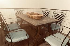 un tavolo in legno con sedie e un cesto di Apartamentos El Paso a Pedrera