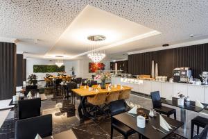 Un restaurante con mesas y sillas y una cocina. en salinenparc Design Budget Hotel, en Erwitte