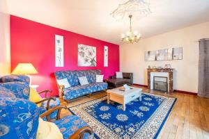 - un salon avec un mur rouge dans l'établissement Chambre Songes d'Afrique, à Montournais