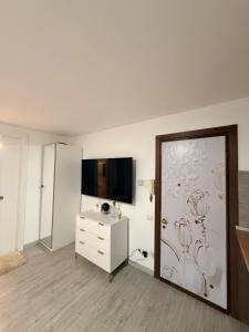 a white room with a sliding glass door with a tv at Orchidea Apartment in Breuil-Cervinia