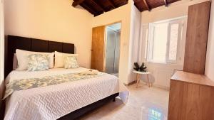 a bedroom with a large bed and a window at Casa La Morada in Medellín