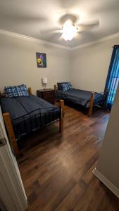什里夫波特Charming, Quiet, South Shreveport Retreat King Bed的一间带两张床和吊扇的卧室
