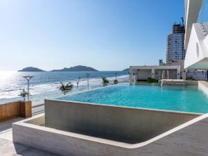 una piscina con l'oceano sullo sfondo di De lujo Con vista al mar en el Malecon a Mazatlán