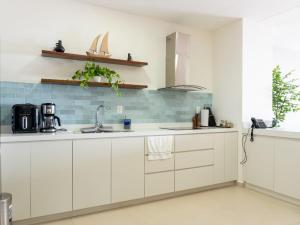 una cucina con mobili bianchi e un lavandino di De lujo Con vista al mar en el Malecon a Mazatlán Altre 48 foto