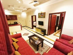 a living room with a red couch and a table at Triple One Premier in Abbottabad