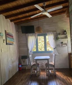 a table and chairs in a room with a window at la cabanita pinamar in Pinamar