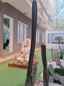 une statue dans le jardin d'une maison avec des cactus dans l'établissement Mantra Apart, à La Rioja
