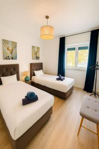 Una habitación con dos camas y una silla dentro. en Cascais Ocean Apartment, en Cascais