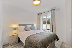 um quarto com uma cama grande e uma janela em 2 Rushbrooke Hotel Apartments Cobh County Cork em Cobh