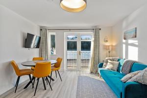 uma sala de estar com um sofá azul e uma mesa e cadeiras em 2 Rushbrooke Hotel Apartments Cobh County Cork em Cobh