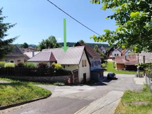 a house with a metal roof on a street at Tichá chalupa in Liptovský Hrádok