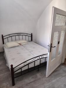 a bed with a wooden frame and a open door at Tichá chalupa in Liptovský Hrádok