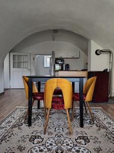 a dining room table with yellow chairs in a kitchen at Tichá chalupa in Liptovský Hrádok