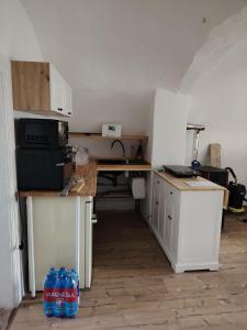 a room with a kitchen with a desk and a microwave at Tichá chalupa in Liptovský Hrádok +3 photos