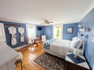 a bedroom with blue walls and a bed and a table at Applewood Inn Bed and Breakfast in Twillingate