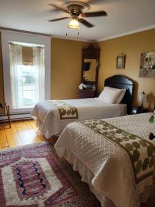 a bedroom with two beds and a ceiling fan at Applewood Inn Bed and Breakfast in Twillingate +6 photos