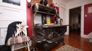 an old fashioned stove in a room with a brick wall at Applewood Inn Bed and Breakfast in Twillingate
