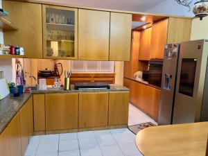 a kitchen with wooden cabinets and a stainless steel refrigerator at private room in Seveso