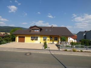 une maison jaune avec un toit brun dans l'établissement Ferienwohnung Simon In Gleißenberg, à Gleißenberg