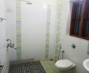 a bathroom with a toilet and a shower and a sink at Thistle Cosy Villa in Kozhikode +34 photos