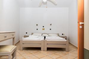 a room with two beds and a table and a door at Villa Maria in Kokkari