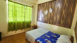 Una pequeña habitación con una cama y una ventana. en Sagada Staycation near Sea of Clouds View, en Sagada