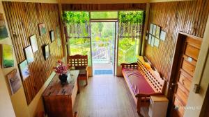 sala de estar con bancos, mesa y ventanas en Sagada Staycation near Sea of Clouds View, en Sagada