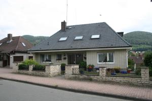 ein Haus mit einem Steinzaun davor in der Unterkunft Ferienwohnung Baude in Bad Harzburg