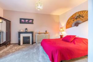 a bedroom with a red bed and a fireplace at Chambre Nuit d'Asie in Montournais
