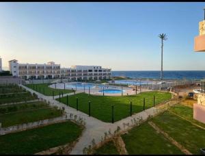 a resort with a pool and the ocean in the background at Modern Front Seaview chalet El Sokhna in Ain Sokhna
