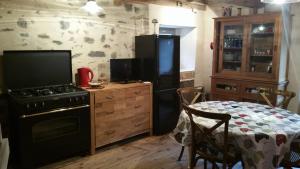 a kitchen with a stove and a table in it at Maison du pâtre in Urbanya