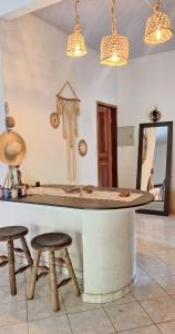 a kitchen with a counter and stools in a room at TRIBUS Hospedagem e Terapias in Alter do Chao