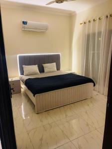 una camera da letto con un letto con una coperta blu di Luxury & Cozy Villa In the Heart of Bahria Town a Karachi