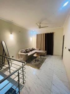un soggiorno con un letto e una scala di Luxury & Cozy Villa In the Heart of Bahria Town a Karachi