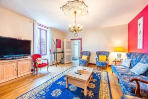 a living room with a couch and a tv at Chambre Nuit d'Asie in Montournais