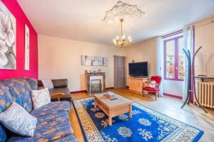 a living room with a couch and a table at Chambre Nuit d'Asie in Montournais +2 photos