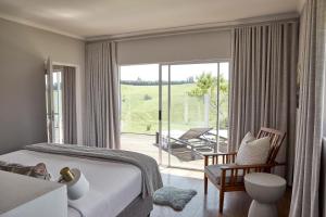 a bedroom with a bed and a sliding glass door at Brahman Hills - Gardens, Spa, Hotel & Villas - 5star in Nottingham Road +109 photos