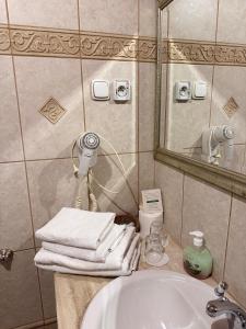 a bathroom with a sink and a mirror and towels at Rezydencja Janków in Iłowa