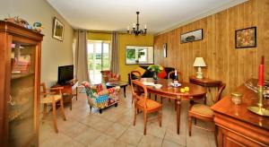 un salon avec une table et des chaises dans l'établissement Chalet Le Tilleul, à Salignac Eyvigues